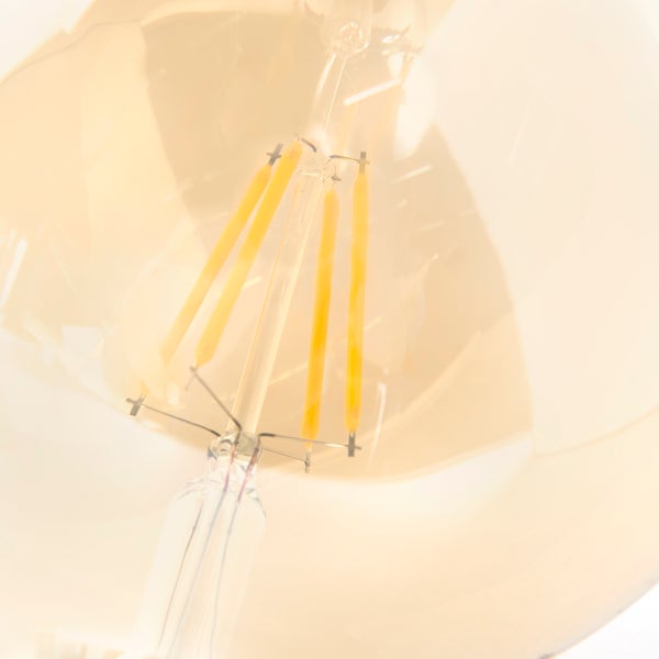 Nahaufnahme der LED-Filamente im Inneren eines Leuchtmittels aus Glas.