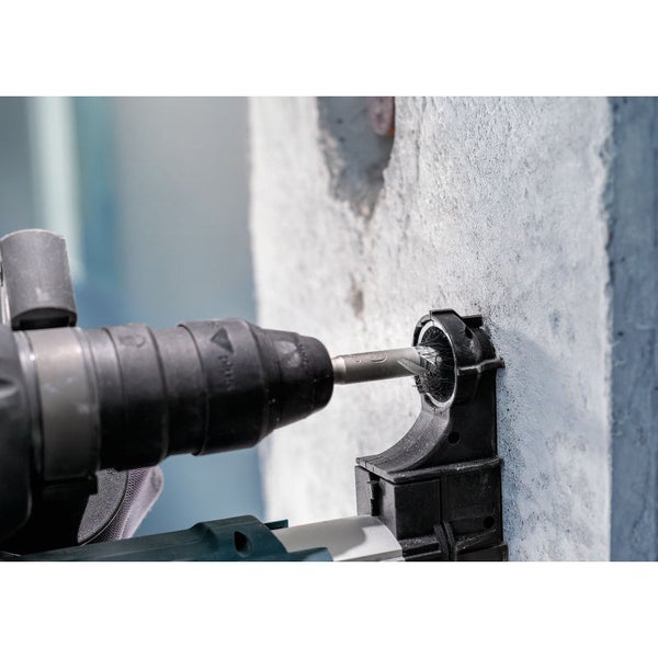 Bohrmaschine bohrt in eine Wand mit Bohrstaubabsaugung