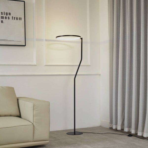 Moderne LED Stehleuchte mit ringförmigem Kopf und schwarzem Gestell, platziert in einem hellen Wohnzimmer neben einem Sofa und Vorhängen.