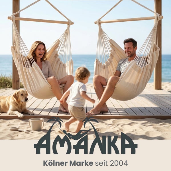 Zwei cremefarbene Hängesessel aus Stoff auf einer Holzterrasse am Strand mit Personen und einem Hund. AMANKA Logo.