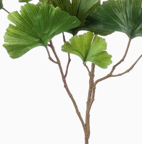 Künstlicher Palmzweig mit langen, schmalen grünen Blättern.