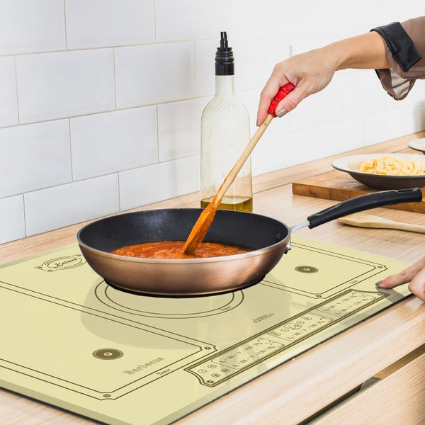 Beige Induktionskochfeld mit Kaiser Logo auf einer Arbeitsplatte, während eine Pfanne mit Tomatensoße darauf zubereitet wird.