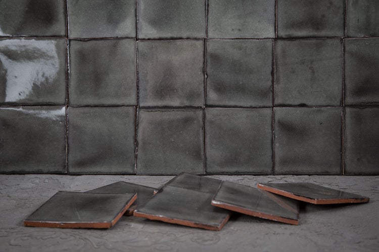 Quadratische, dunkle Fliesen für Wand und Boden