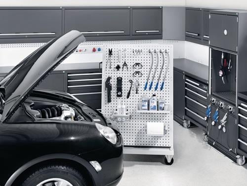 Garage mit Auto, Werkzeugwand und Werkstatteinrichtung für die Werkzeugaufbewahrung.