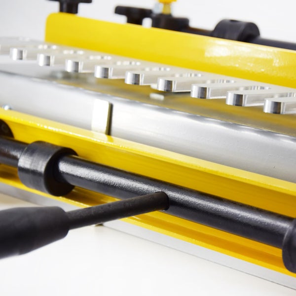 Detailansicht einer Fingerzinkenfräse mit gelben und silbernen Elementen