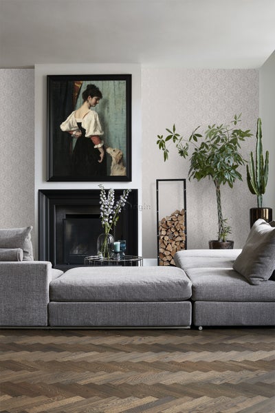 Wohnzimmer mit grauer Couch, Kamin, Gemälde und dekorativer Wandtapete für ein stilvolles Interieur.