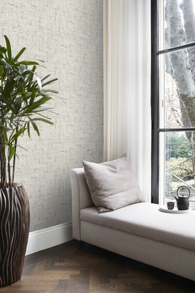 Wohnzimmer mit gemusterter Tapete, Liege und Zimmerpflanze