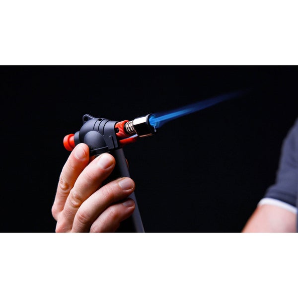 Hand hält einen Bunsenbrenner mit blauer Flamme