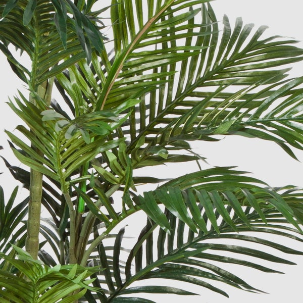 Detailansicht einer künstlichen Palme mit grünen Blättern und Stielen.