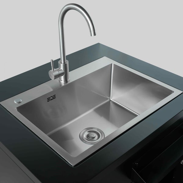 Einbauspüle aus Edelstahl mit einem Becken und hoher Küchenarmatur auf einer dunklen Arbeitsplatte.