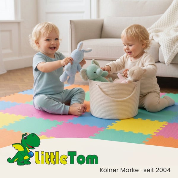 Zwei Kleinkinder spielen auf einer bunten Puzzlematte aus Schaumstoff mit Kuscheltieren und einem Aufbewahrungskorb. Little Tom Logo.