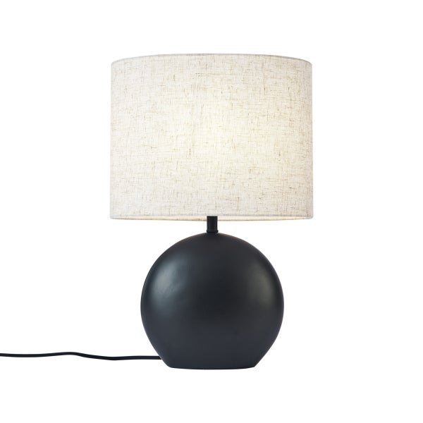 Moderne Tischleuchte mit schwarzem kugelförmigem Fuß und zylindrischem Textilschirm aus beigem Leinenstoff.