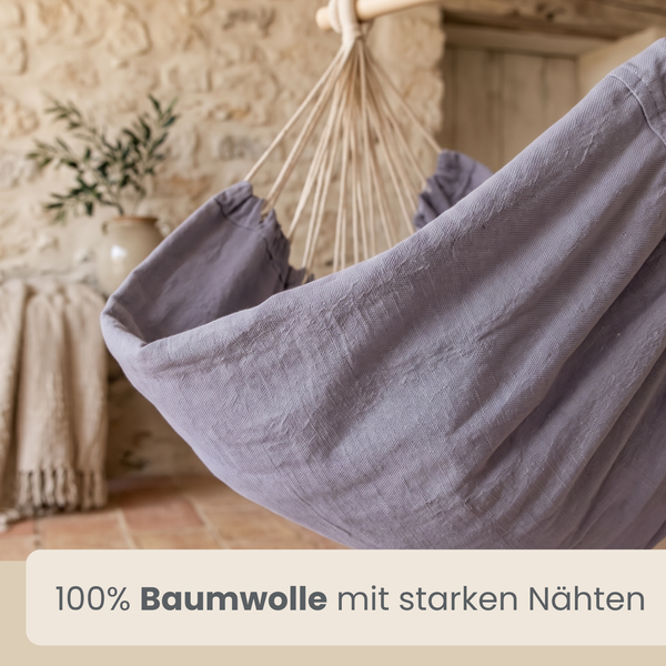 Hängesessel aus 100 Prozent Baumwolle mit stabilen Nähten in rustikaler Wohnumgebung mit Natursteinwand.