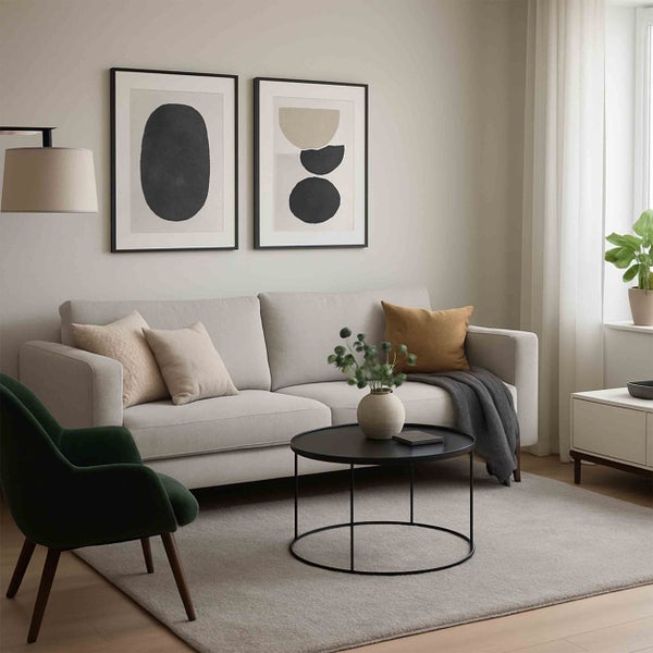 Modernes Wohnzimmer mit hellem Sofa, dunkelgrünem Sessel, schwarzem Couchtisch, Teppich und abstrakten Wandbildern.