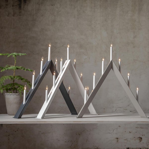 Zwei skandinavische Adventsleuchter mit elektrischen Kerzen auf einem Tisch.