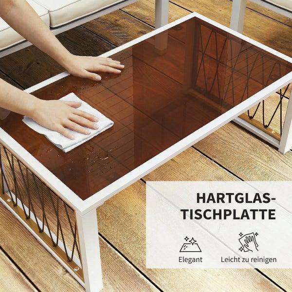 Eine Person wischt die Hartglas-Tischplatte eines weißen Garten-Couchtischs auf einer Holzterrasse ab. Symbole für Eleganz und einfache Reinigung.