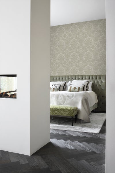 Schlafzimmer mit Bett, Sitzbank, Tapete und Kamin