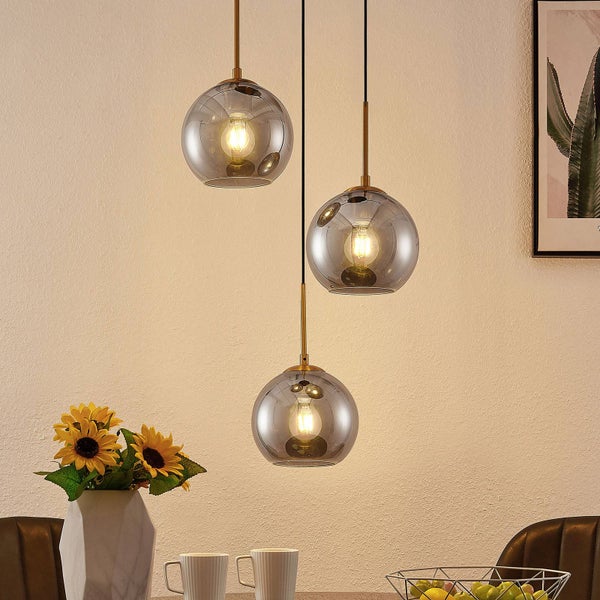 Dreiflammige Pendelleuchte mit Glaskugelschirmen über einem Esstisch