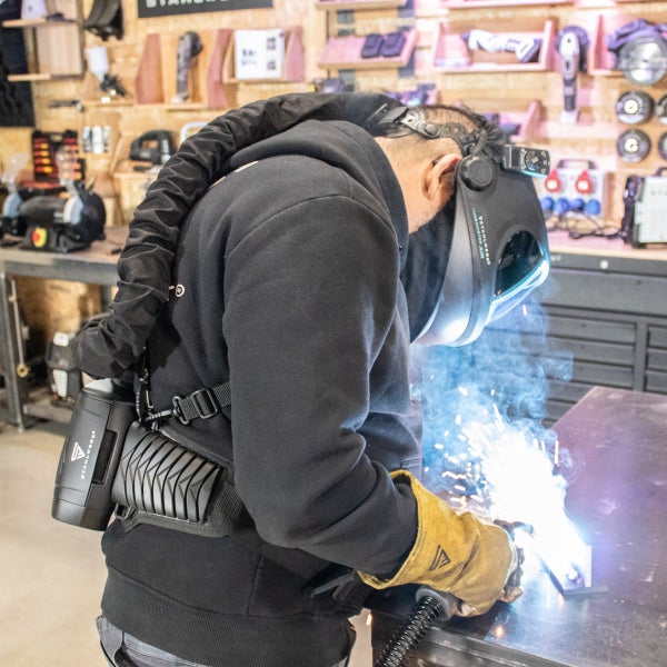 Schweißer bei der Arbeit mit Schweißhelm und Atemschutzsystem