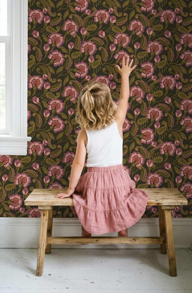Blumentapete mit stilisierten Blüten und Blättern in einem hellen Zimmer mit Holzbank und Kind.