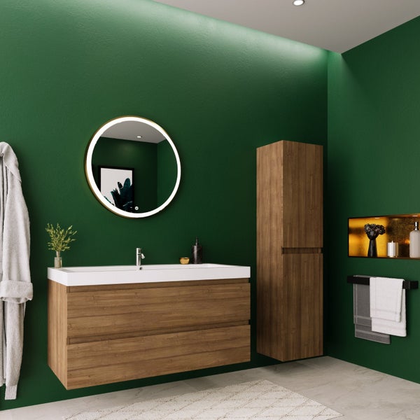 Modernes Badezimmer mit Waschtischunterschrank in Holzoptik, rundem LED-Spiegel, Hochschrank und Badaccessoires vor einer dunklen Wand.