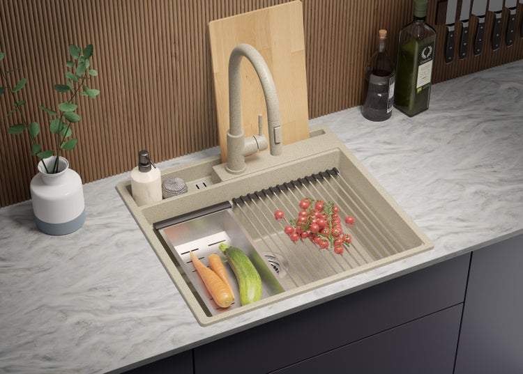 Küchenspüle mit Abtropffläche, Armatur, Schneidebrett und Lebensmitteln auf einer Küchentheke.