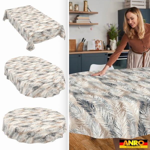 Wachstuch-Tischdecke mit Palmenblatt-Muster in verschiedenen Formen. Eine Frau deckt einen Tisch in einer Küche. ANRO Deutsche Manufaktur Logo.