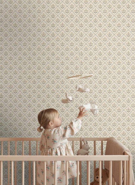 Vliestapete mit floralem Muster in einem hellen Kinderzimmer mit einem Kind in einem Gitterbett.