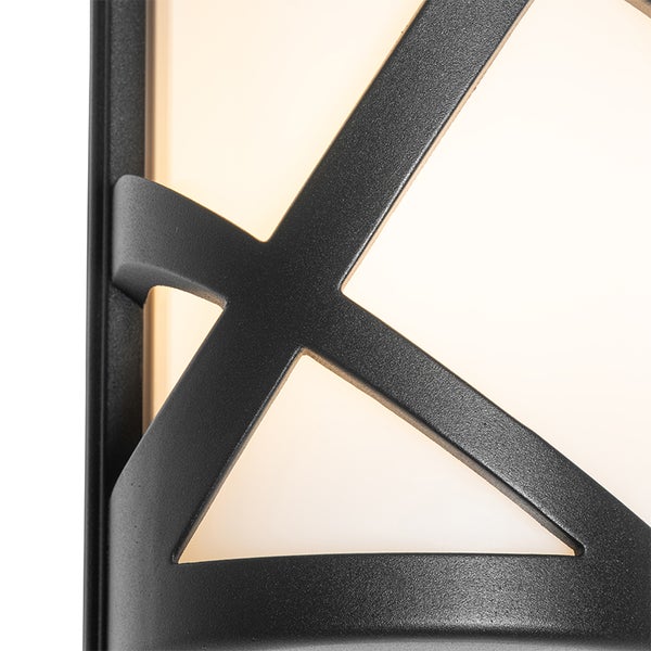 Nahaufnahme einer Außenwandleuchte mit schwarzem Metallrahmen und geometrischem Muster.