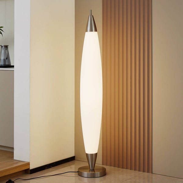 Moderne spindelförmige Stehleuchte mit weißem Schirm und Metallsockel in einem hellen Zimmer.