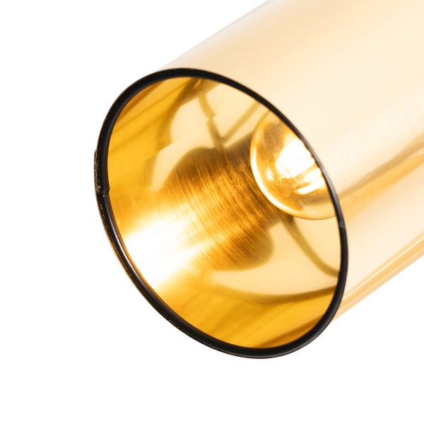 Nahaufnahme einer goldenen Röhrenleuchte mit einer Glühbirne im Inneren