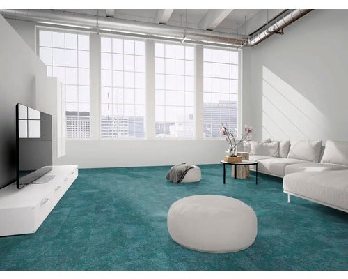 Hell gestalteter, großzügiger Loft mit petrolfarbenem Teppichboden, großen Fenstern, weißem Sofa und modernen Möbeln.