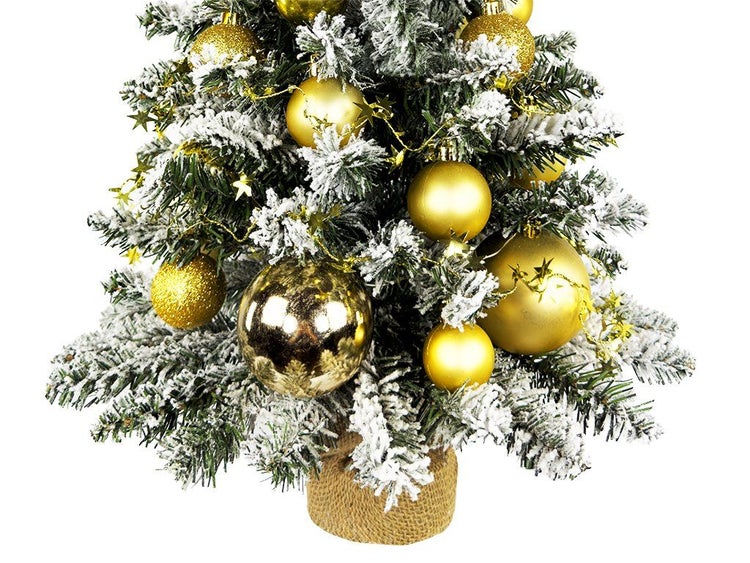 Künstlicher Weihnachtsbaum mit künstlichem Schnee und goldener Dekoration im Jutesack als Tischdekoration