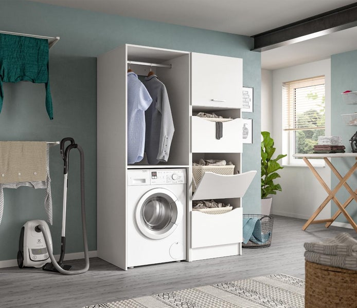 Weißer Waschmaschinenschrank mit Wäschefächern, integriert in einem organisierten Hauswirtschaftsraum mit Bügelbrett und Staubsauger.