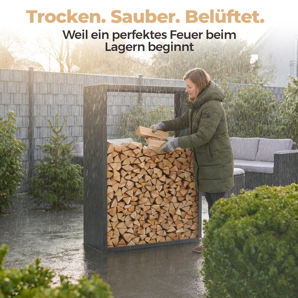 Eine Frau stapelt Brennholz in ein schwarzes Brennholzregal aus Metall in einem Garten bei Regen.