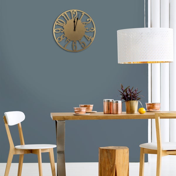 Esszimmer mit Holztisch, Stühlen, Lampe und goldener Wanduhr