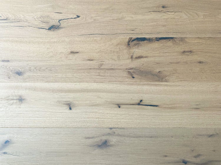 Holzbodenbelag in Eichenoptik mit ausgeprägter Maserung, Astlöchern und dunklen Rissen.