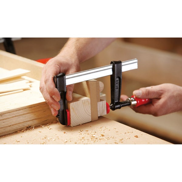 Eine Schraubzwinge fixiert Holzstücke bei der Holzbearbeitung.