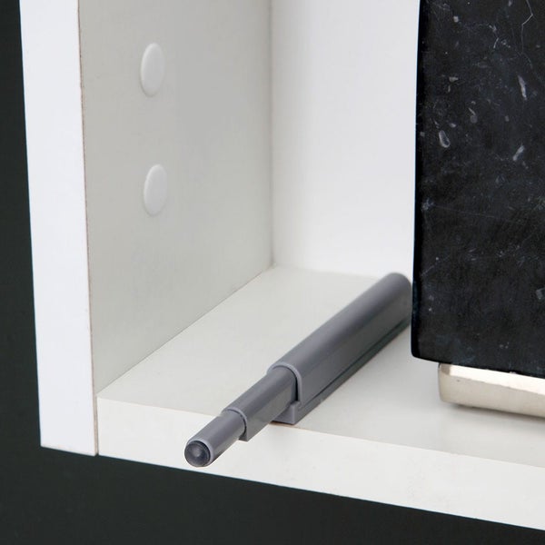 Grauer Drucktüröffner aus Kunststoff montiert in einem weißen Schrank für grifflose Türen.