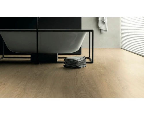 Badezimmer mit Badewanne, Handtüchern und hellem Holzboden