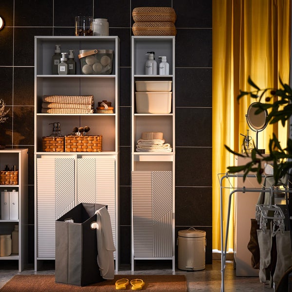 Badezimmeransicht mit Regalen, Wäschekorb und Accessoires