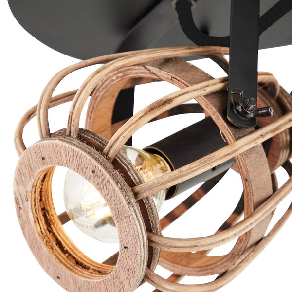 Nahaufnahme eines Strahlers mit Käfigschirm aus Holz und einer sichtbaren Lichtquelle an einer schwarzen Metallhalterung.