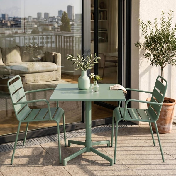 Ein quadratischer Gartentisch aus Metall und zwei passende Gartenstühle mit Armlehnen auf einem modernen Balkon.