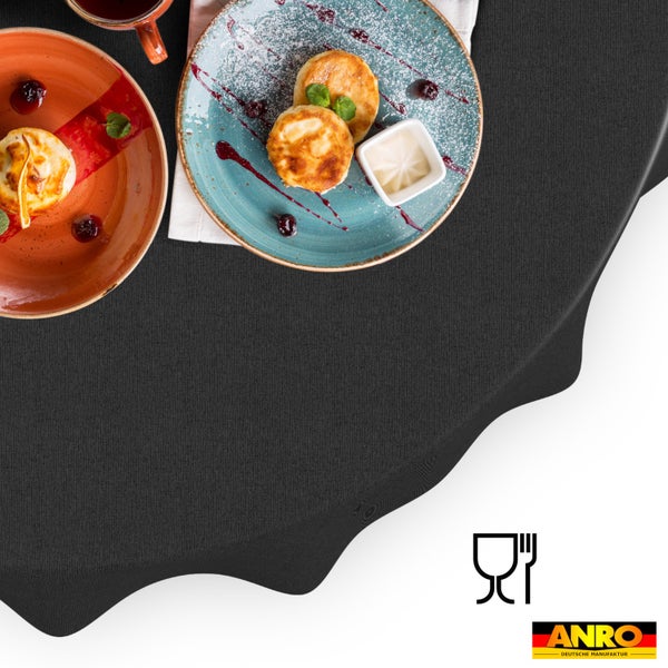 Strukturierte, dunkelgraue Tischdecke aus lebensmittelechtem Material auf einem gedeckten Tisch. ANRO Logo.