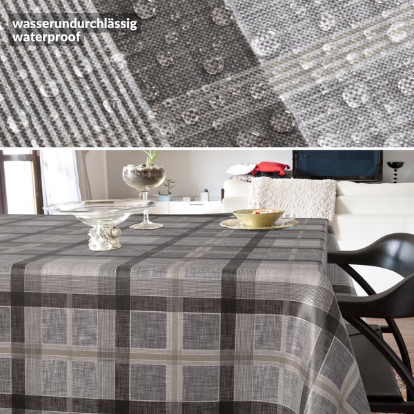 Wasserdichte Tischdecke mit Karomuster auf einem Tisch im Wohnzimmer, Detailaufnahme der wasserundurchlässigen Oberfläche mit Wassertropfen.
