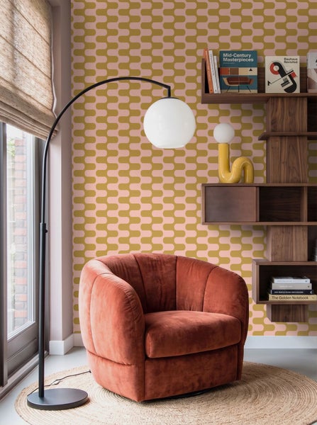 Wohnraum mit gemusterter Tapete, einem Polstersessel und einem dunklen Holzregal in einem modern gestalteten Innenraum.