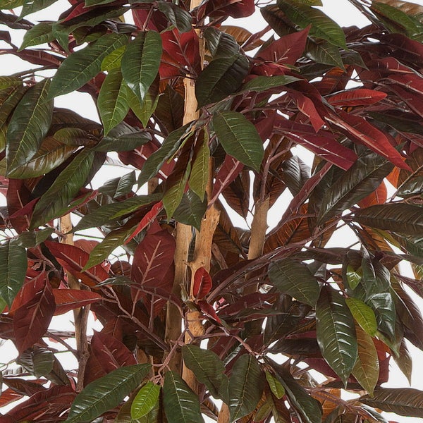 Nahaufnahme einer künstlichen Pflanze mit grünen und dunkelroten Blättern sowie einem sichtbaren Holzstamm.