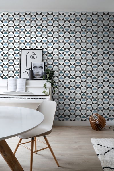 Wohnraum mit geometrischer Tapete, weißem Klavier und Esstisch