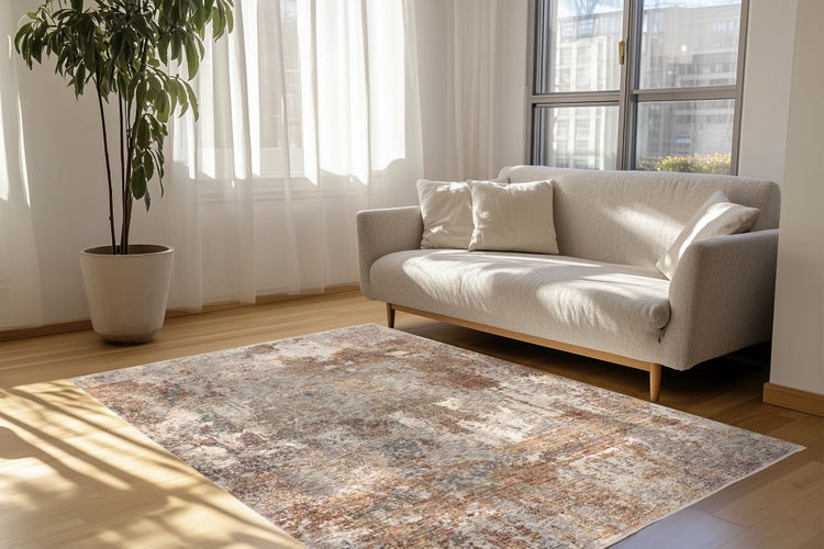 Helles Wohnzimmer mit einem modernen Sofa, einer Zimmerpflanze und einem gemusterten Teppich auf einem Holzboden.