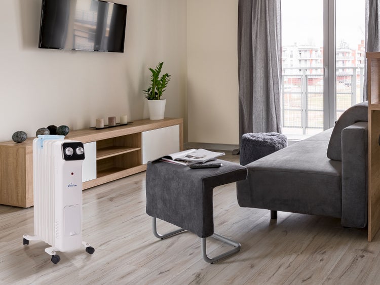 Wohnzimmer mit Heizkörper, Sofa, Tisch und Fernseher für eine gemütliche Atmosphäre